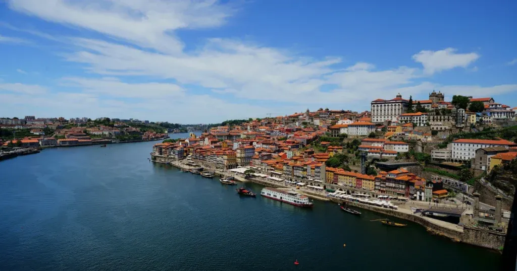 A scenic view of Porto, Portugal, with colorful buildings lining the Douro River, highlighting one of the best air routes to travel Spain and Portugal.