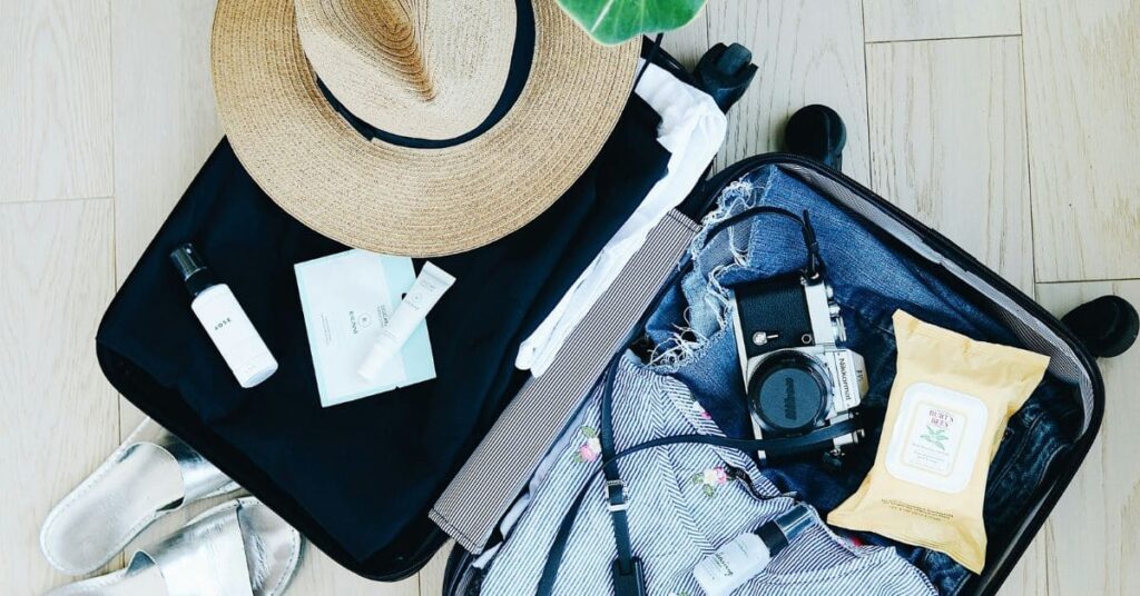 Efficient packing for small luggage for 3 week travel, featuring neatly arranged items, packing cubes, and travel essentials.