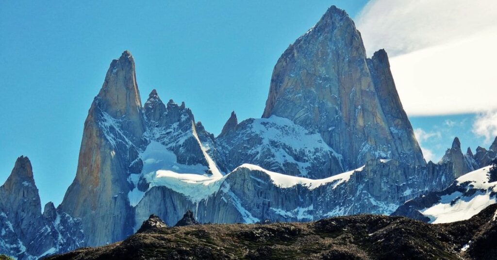 A breathtaking view of Patagonia's mountains, featuring rugged peaks, lush valleys, and clear blue skies.