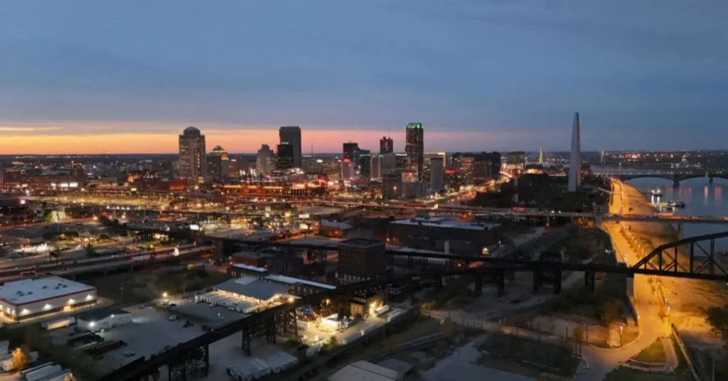 A scenic view of downtown St. Louis at sunset, featuring the Gateway Arch and city lights – a must-see when exploring things to do in St Louis this weekend.