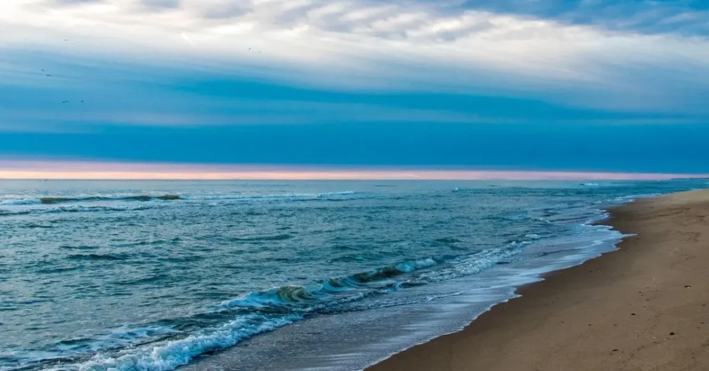 Serene beach scene with gentle waves lapping the shore in Monmouth County, showcasing family friendly things to do Monmouth County for a relaxing family outing.