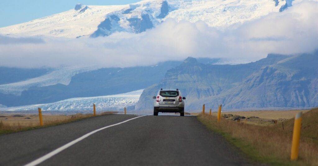 How long will it take me to travel 10 miles? A question mark hovers above a silver SUV driving on a highway, indicating uncertainty about travel time.