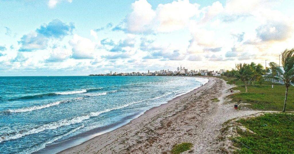 A scenic view of Miramar Beach with clear blue waters, soft white sand, and visitors enjoying beach activities—one of the best things to do in Miramar Beach.