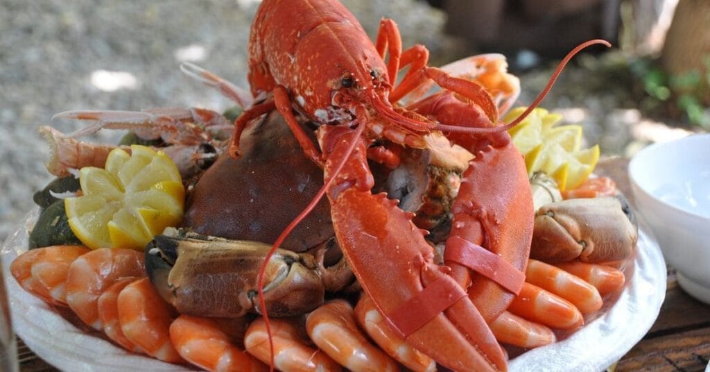 A delicious seafood platter featuring fresh shrimp, crab, and fish, served with lemon and dipping sauces—one of the must-try things to do in Miramar Beach.