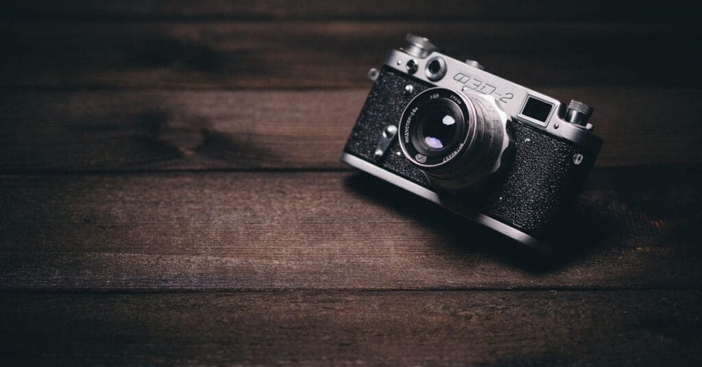 A classic vintage camera placed on a wooden surface, perfect for travelers searching for the best camera for travel.