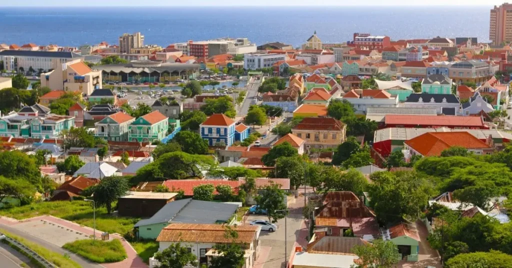 Aerial view of the colorful town of Oranjestad, Aruba, showcasing its vibrant architecture and lush green spaces during the best time to visit Aruba for a perfect vacation.