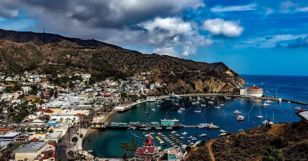 Scenic view of Avalon Bay showcasing the best things to do in Catalina Island, featuring the Catalina Casino, a bustling harbor with boats, and a charming town set against a mountainous backdrop.