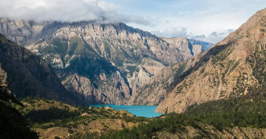 A breathtaking view of a turquoise lake surrounded by rugged mountains, showcasing one of the best places to travel to in February.