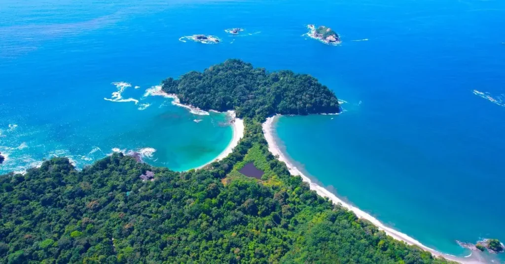 A stunning aerial view of a tropical beach with turquoise waters and lush greenery, making it one of the best places to travel to in February.