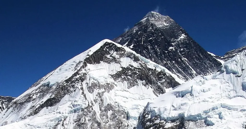 A stunning view of Mount Everest under a clear blue sky, showcasing its snow-covered peak. Learn what is the best hour to visit Mount Everest for breathtaking views and safe climbing conditions.