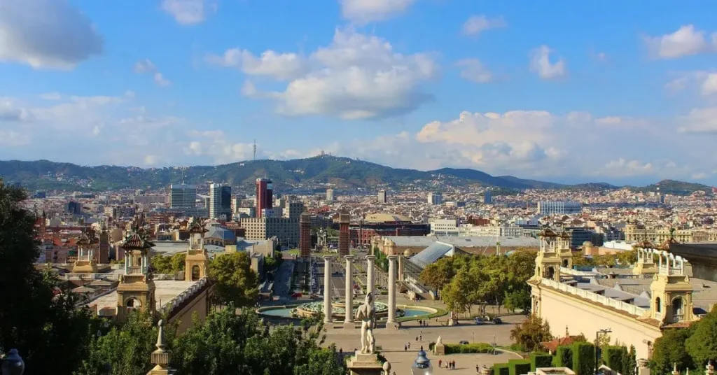 A panoramic view of Barcelona, Spain, from a high vantage point, showing the cityscape with mountains in the background, making it one of the best destinations to visit in September with its pleasant weather and vibrant atmosphere.