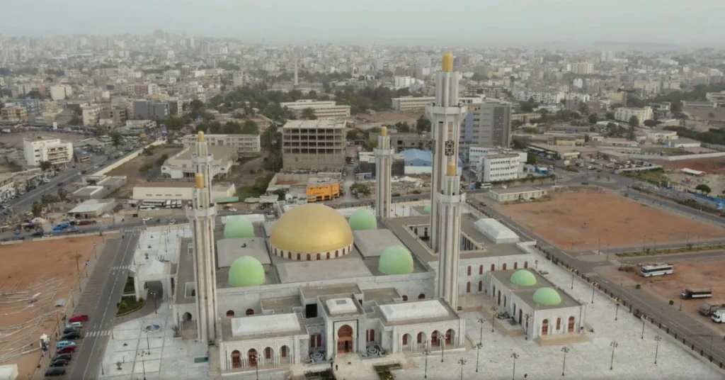 Aerial view of the Grand Mosque of Dakar, a must-see destination after booking a flight ticket to Senegal, featuring a golden dome and towering minarets.