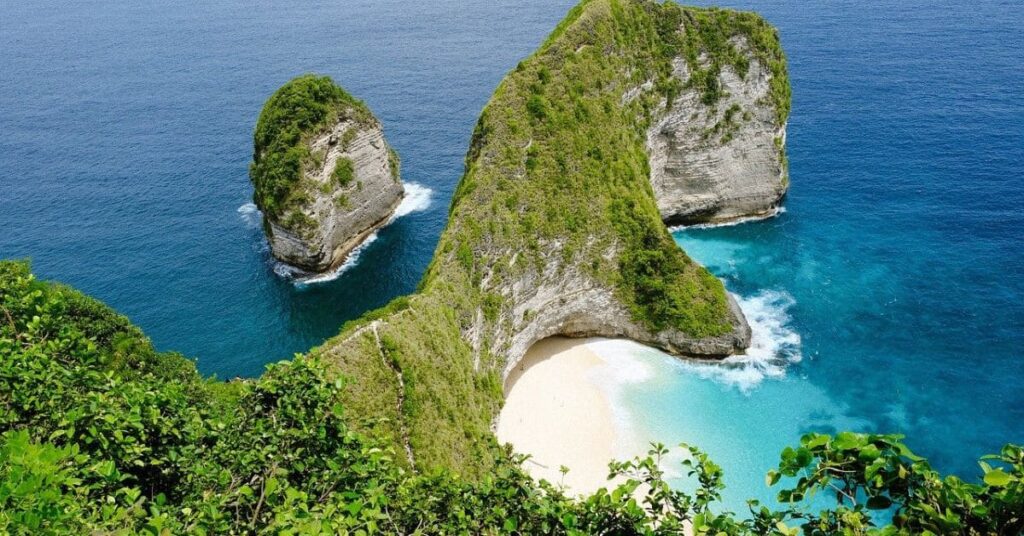 A breathtaking aerial view of Kelingking Beach on Nusa Penida, showcasing a T-Rex shaped cliff against the turquoise ocean, a must-see among tropical places to visit.