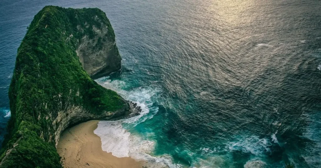 Breathtaking view of Kelingking Beach in Bali, Indonesia, one of the best Asian countries to visit, featuring turquoise waters, white sand, and lush green cliffs.